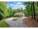 A beautiful view of this home from a distance, surrounded by mature trees at 1825 Epperson Rd, Canton, GA 30115