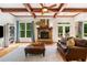 Bright living room boasts a stone fireplace, wood beams, hardwood floors, and ample natural light at 1825 Epperson Rd, Canton, GA 30115