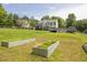 The large backyard features a garden, playhouse, and pool, set amongst mature trees on a sunny day at 2180 Oakpointe Ct, Buford, GA 30519