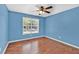 Bright bedroom with wood floors, a ceiling fan, and a large window for natural light at 2180 Oakpointe Ct, Buford, GA 30519