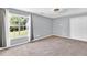 Bedroom featuring neutral carpet, ceiling fan, closet and a window with backyard view at 2180 Oakpointe Ct, Buford, GA 30519