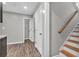 Hallway with wood-look flooring, white doors, and staircase with wooden handrail at 2180 Oakpointe Ct, Buford, GA 30519