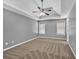The main bedroom features a trey ceiling, ceiling fan, and neutral carpet and paint at 2180 Oakpointe Ct, Buford, GA 30519