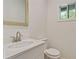 Bright bathroom with white cabinetry, a modern faucet and a mirror overlooking the lush green yard at 70 Wheeler Lake Path, Dallas, GA 30157