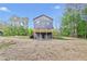 Exterior view of new two-story home, featuring a backyard fire pit and second-story deck with a private, wooded backdrop at 70 Wheeler Lake Path, Dallas, GA 30157
