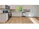 The kitchen has white cabinets, a stainless dishwasher, a gas range and granite countertops at 70 Wheeler Lake Path, Dallas, GA 30157