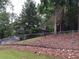Home exterior with chain link fence and mature trees at 135 Golden Hills Dr, Woodstock, GA 30189