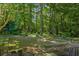 Picturesque backyard featuring mature trees, manicured landscaping and an outdoor seating area at 2191 Flowering Dr, Grayson, GA 30017