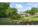 Large grassy backyard with mature trees surrounding a single-Gathering home on a sunny day at 2191 Flowering Dr, Grayson, GA 30017