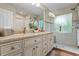 Bright bathroom featuring a granite countertop, dual sinks, and a glass-enclosed shower at 2191 Flowering Dr, Grayson, GA 30017