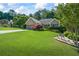 Beautifully landscaped front yard with lush green grass, mature trees, and an inviting curb appeal at 2191 Flowering Dr, Grayson, GA 30017