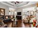 Open-concept living room with tray ceiling, hardwood floors, and adjacent dining area at 2191 Flowering Dr, Grayson, GA 30017