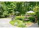 Backyard retreat with decorative fountain and a small stone patio bordered by greenery and mature trees at 386 Collegiate Dr, Powder Springs, GA 30127