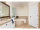 Bathroom featuring granite countertop, soaking tub, and tile surround at 386 Collegiate Dr, Powder Springs, GA 30127