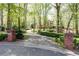 Long driveway leading to a home surrounded by lush trees and landscaping at 386 Collegiate Dr, Powder Springs, GA 30127