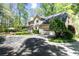 Charming home exterior featuring a two-car garage, beautiful landscaping, and outdoor dining space at 386 Collegiate Dr, Powder Springs, GA 30127