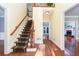 Inviting foyer with hardwood floors, staircase, and views into the living spaces at 386 Collegiate Dr, Powder Springs, GA 30127