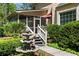 Charming front entrance with lush landscaping, fountain, and screened porch access at 386 Collegiate Dr, Powder Springs, GA 30127
