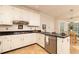 Bright kitchen with stainless steel appliances, granite counters, and white cabinets at 386 Collegiate Dr, Powder Springs, GA 30127