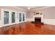 This living room features hardwood floors, a fireplace, a ceiling fan, and double doors leading outside at 386 Collegiate Dr, Powder Springs, GA 30127