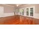 This living room features hardwood floors, wainscoting, a ceiling fan, and double doors leading outside at 386 Collegiate Dr, Powder Springs, GA 30127