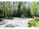 Large parking pad with a view of a manicured wooded backyard at 386 Collegiate Dr, Powder Springs, GA 30127
