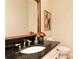 Stylish powder room featuring a granite countertop, gold faucet, and decorative accents at 386 Collegiate Dr, Powder Springs, GA 30127