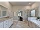 Bright and airy bathroom with a dual sink vanity, soaking tub, glass shower, and neutral tile flooring at 3925 Sierra Knolls Ct, Cumming, GA 30040