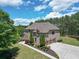 Expansive brick home with three-car garage, mature trees, and beautifully landscaped grounds at 105 New Castle Ln, Tyrone, GA 30290