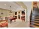 Finished basement area with billiards table, staircase and built in bar with shelving at 105 New Castle Ln, Tyrone, GA 30290