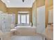 Spacious bathroom featuring a soaking tub under a window and a glass-enclosed shower at 105 New Castle Ln, Tyrone, GA 30290