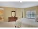 Charming bedroom with a four-poster bed, dresser, and a large window, offering plenty of natural light at 105 New Castle Ln, Tyrone, GA 30290