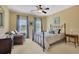 Bedroom featuring large bed, window views, ceiling fan and sitting area with leather chair at 105 New Castle Ln, Tyrone, GA 30290