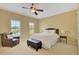 Bright bedroom featuring a ceiling fan, a comfortable queen-size bed, and a cozy armchair at 105 New Castle Ln, Tyrone, GA 30290