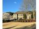 Beautiful brick home with manicured lawn, mature trees, and meticulously maintained landscaping at 105 New Castle Ln, Tyrone, GA 30290