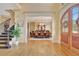 Welcoming foyer featuring hardwood floors, staircase, elegant lighting and a decorative arched door at 105 New Castle Ln, Tyrone, GA 30290