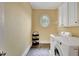 Laundry room with round window, tiled floor, and front loading washer and dryer at 105 New Castle Ln, Tyrone, GA 30290