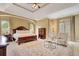 Main bedroom with tray ceilings, a sitting area, and a large rug at 105 New Castle Ln, Tyrone, GA 30290