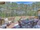 Outdoor seating area on a wooden deck with a large backyard and mature trees in the background at 105 New Castle Ln, Tyrone, GA 30290