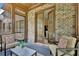 Covered patio with brick walls, cushioned seating, and an inviting atmosphere at 105 New Castle Ln, Tyrone, GA 30290