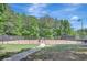 Well-maintained tennis court in a community surrounded by lush trees and landscaping at 105 New Castle Ln, Tyrone, GA 30290