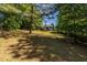 A large backyard with a gentle slope and a view of the home's exterior from the rear at 1215 Smoke Hill Ln, Hoschton, GA 30548