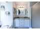 Bright bathroom features dual sinks, granite counters, and glass-enclosed shower at 1215 Smoke Hill Ln, Hoschton, GA 30548