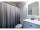 Cozy bathroom with standard white vanity and toilet plus a shower-tub combo with gray curtain at 1215 Smoke Hill Ln, Hoschton, GA 30548