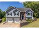 Charming two-story home featuring a well-manicured lawn, two-car garage, and inviting front entrance with tasteful landscaping at 1215 Smoke Hill Ln, Hoschton, GA 30548