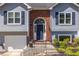Inviting home entrance showcasing a brick archway, dark door, and well-maintained landscaping for curb appeal at 1215 Smoke Hill Ln, Hoschton, GA 30548