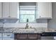 Bright kitchen featuring white cabinets, granite countertops, and a window view at 1215 Smoke Hill Ln, Hoschton, GA 30548