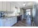 Well-lit kitchen boasts white cabinets, granite countertops, and stainless steel appliances at 1215 Smoke Hill Ln, Hoschton, GA 30548
