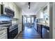 Modern kitchen featuring stainless steel appliances, granite countertops, and dark wood floors at 1215 Smoke Hill Ln, Hoschton, GA 30548