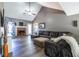 Spacious living room with vaulted ceiling, a brick fireplace, and modern decor at 1215 Smoke Hill Ln, Hoschton, GA 30548